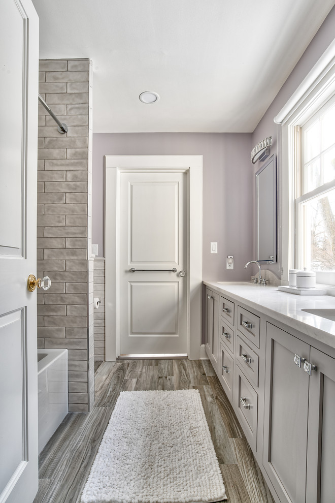 This is an example of a mid-sized modern kids bathroom in New York with beaded inset cabinets, a drop-in tub, a shower/bathtub combo, a one-piece toilet, gray tile, ceramic tile, purple walls, an undermount sink, grey floor and a shower curtain.