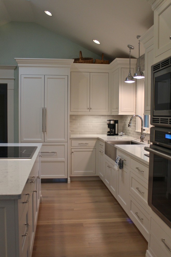 Inspiration for a mid-sized l-shaped dark wood floor eat-in kitchen remodel with flat-panel cabinets, white cabinets, gray backsplash, stainless steel appliances and an island