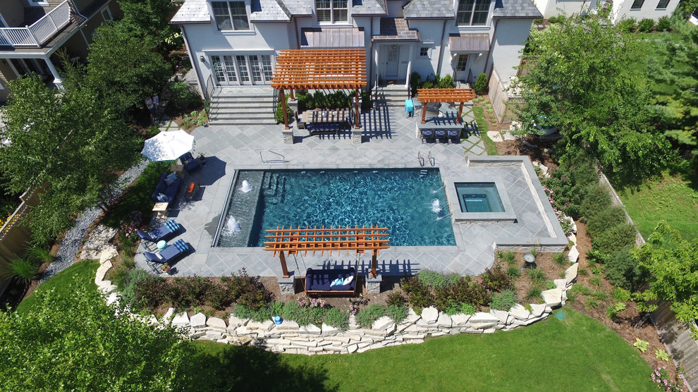 Example of a mid-sized classic backyard stone and rectangular hot tub design in Chicago