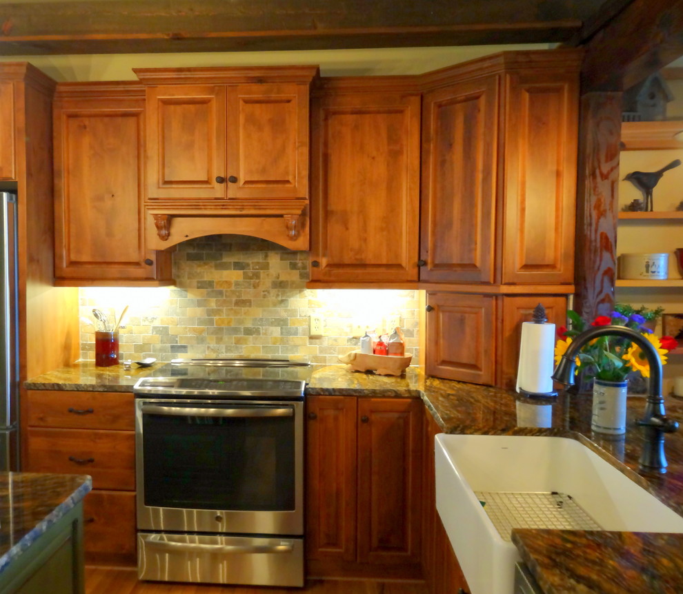 Eat-in kitchen - mid-sized rustic l-shaped medium tone wood floor eat-in kitchen idea in Charlotte with a farmhouse sink, raised-panel cabinets, dark wood cabinets, granite countertops, multicolored backsplash, stone tile backsplash, stainless steel appliances and an island
