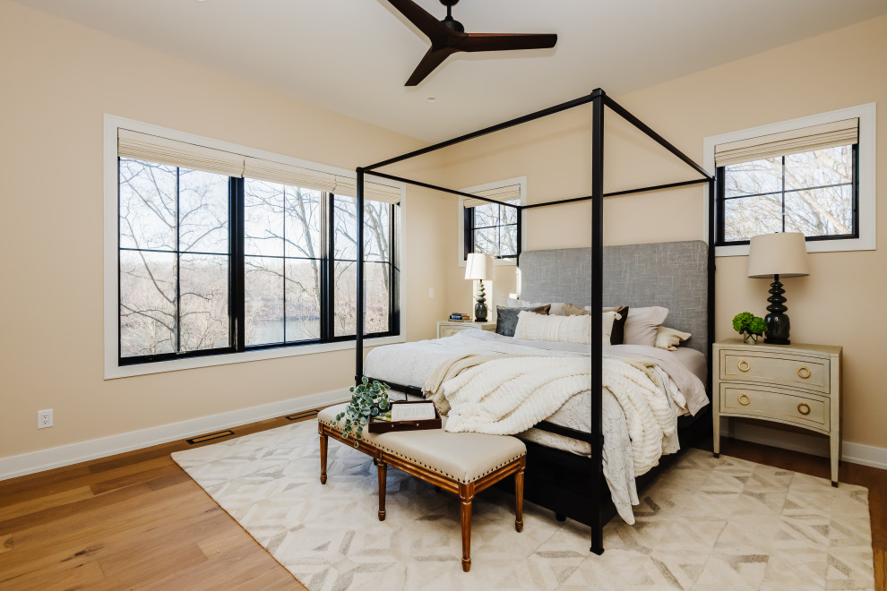 Foto de dormitorio principal campestre de tamaño medio con paredes beige y suelo de madera clara