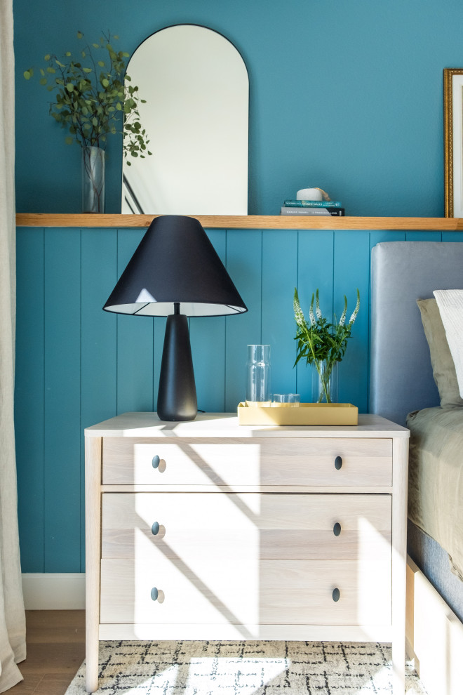 Inspiration for a mid-sized beach style master bedroom in San Diego with blue walls, light hardwood floors, brown floor and planked wall panelling.