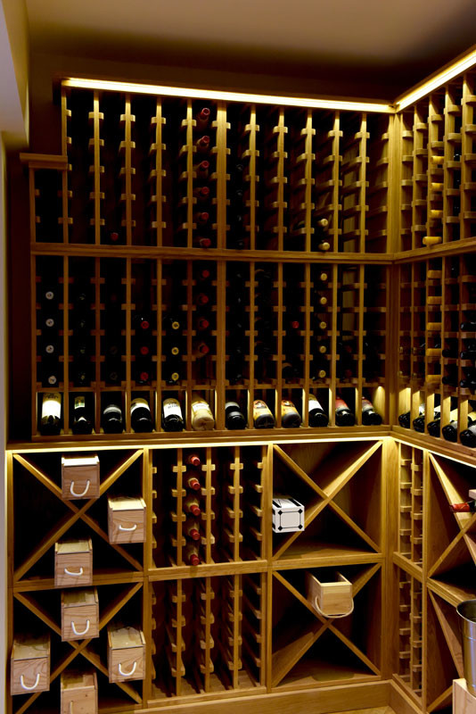 Inspiration for a large contemporary wine cellar in Other with storage racks, light hardwood floors and brown floor.