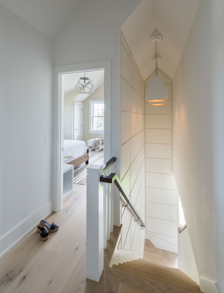 This is an example of a contemporary hallway in Providence with white walls and light hardwood floors.