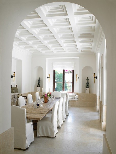 Inspiration for a mid-sized mediterranean kitchen/dining combo in New York with a standard fireplace, a stone fireplace surround, beige walls and limestone floors.