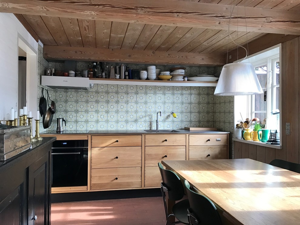 This is an example of a country kitchen in Copenhagen with flat-panel cabinets, medium wood cabinets, multi-coloured splashback and no island.