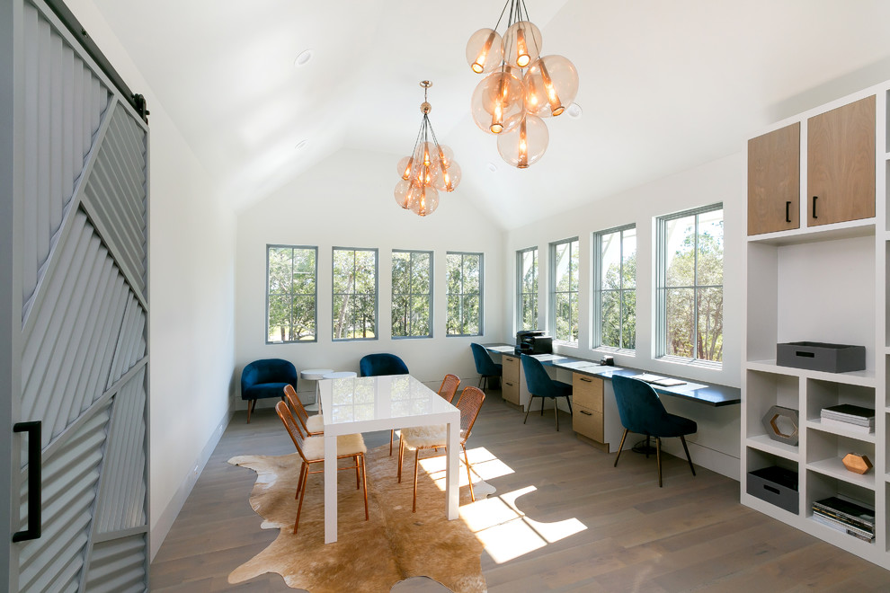 Example of a country gender-neutral light wood floor and brown floor kids' study room design in Charleston with white walls