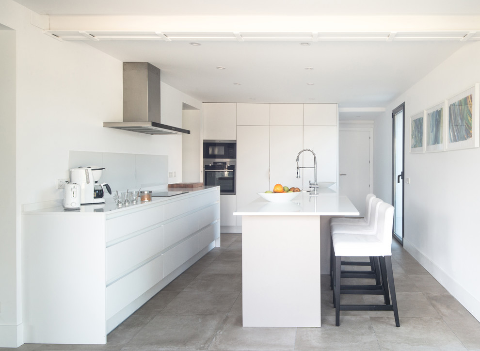 Photo of a large mediterranean single-wall separate kitchen in Madrid with an undermount sink, flat-panel cabinets, white cabinets, quartz benchtops, white splashback, window splashback, panelled appliances, ceramic floors, with island, grey floor and white benchtop.