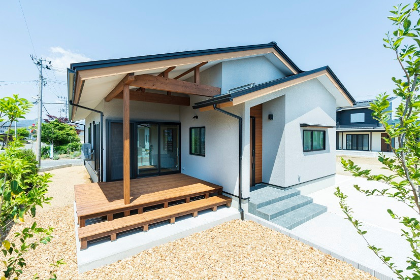 Kleines, Einstöckiges Einfamilienhaus mit Mix-Fassade, grauer Fassadenfarbe, Satteldach, Blechdach und schwarzem Dach in Sonstige