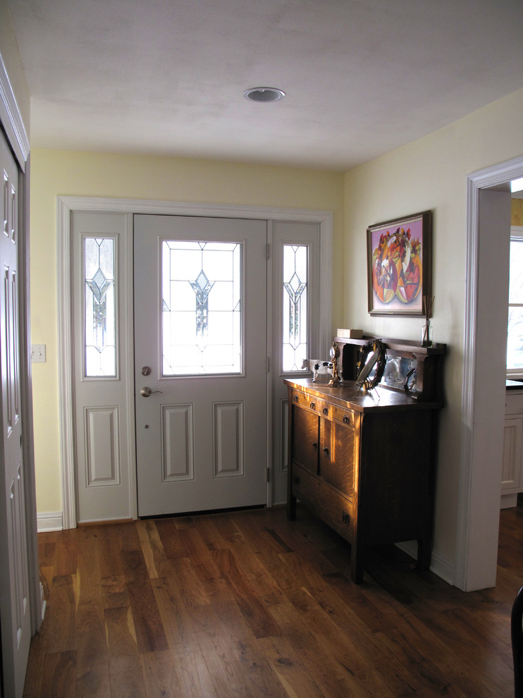 Design ideas for a small country front door in Milwaukee with yellow walls, medium hardwood floors, a single front door and a white front door.