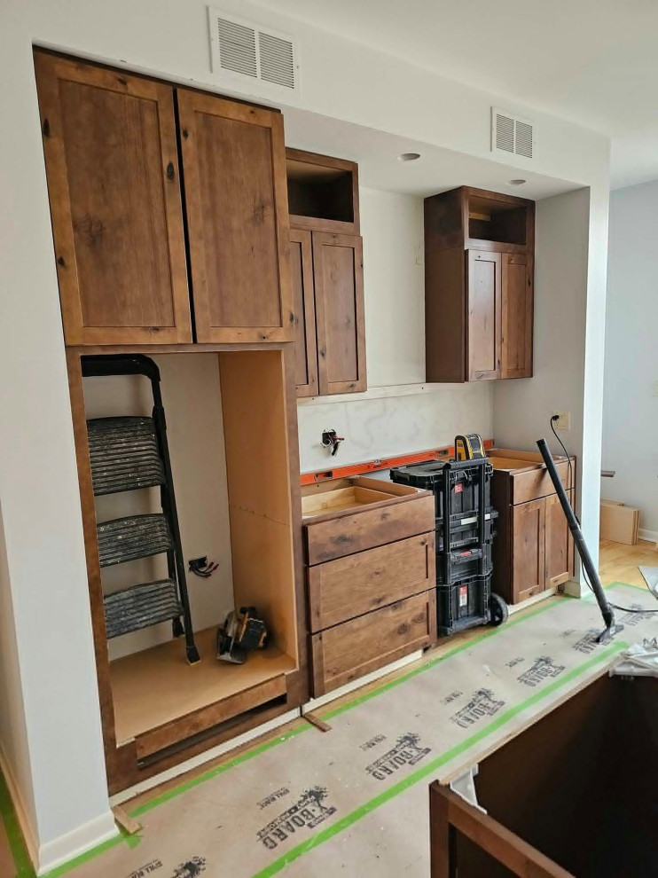 Example of a large transitional medium tone wood floor and brown floor eat-in kitchen design in Chicago with an undermount sink, shaker cabinets, medium tone wood cabinets, quartz countertops, multicolored backsplash, stone tile backsplash, stainless steel appliances, an island and white countertops