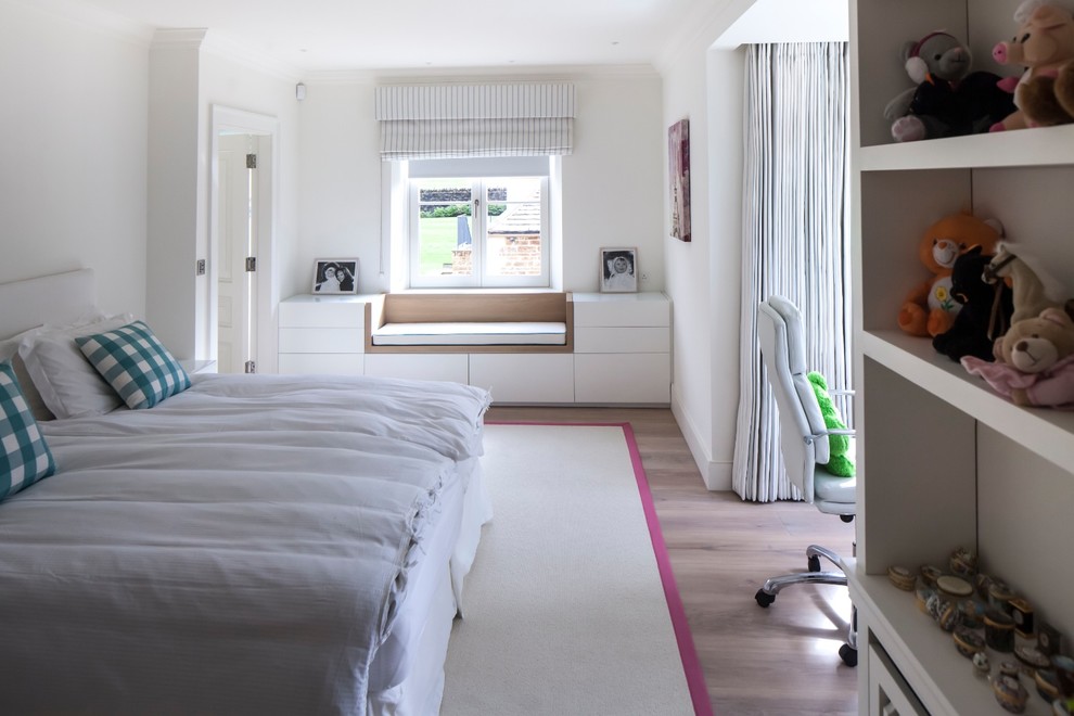 Transitional gender-neutral kids' bedroom in Gloucestershire with white walls and medium hardwood floors.