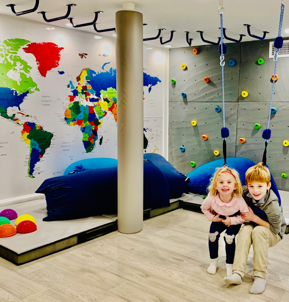 Sensorylicious! - Example of a mid-sized classic gender-neutral laminate floor, gray floor, coffered ceiling and wood wall playroom design in New York with white walls