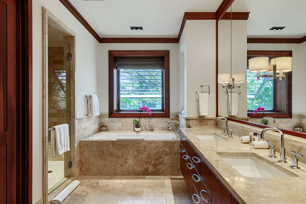 Photo of a large transitional master bathroom in Hawaii with an alcove tub, flat-panel cabinets, brown cabinets, travertine, beige walls, travertine floors, an undermount sink, beige floor, a hinged shower door and an alcove shower.