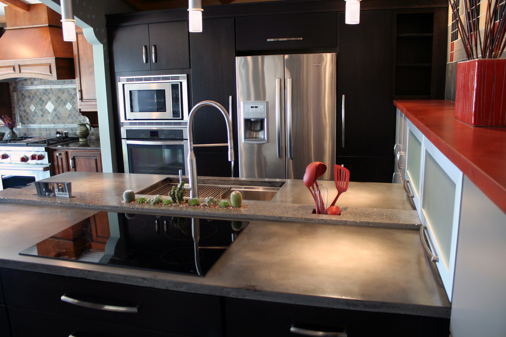 This is an example of a mid-sized contemporary kitchen in Huntington with flat-panel cabinets, black cabinets, concrete benchtops, stainless steel appliances and a peninsula.