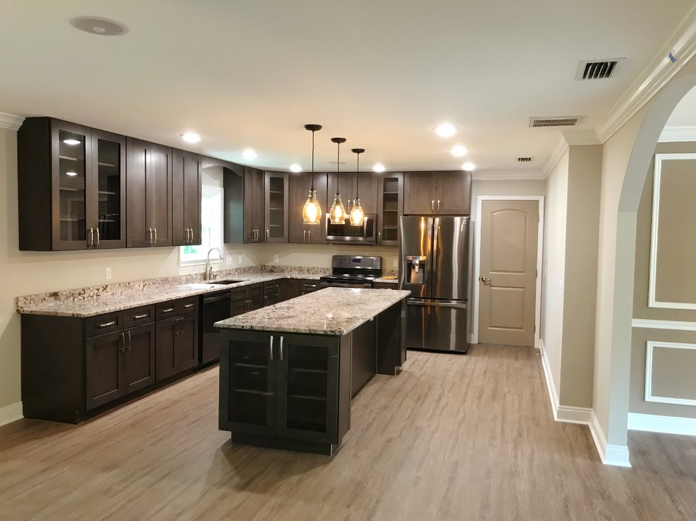 Large transitional l-shaped light wood floor and beige floor eat-in kitchen photo with an undermount sink, shaker cabinets, dark wood cabinets, granite countertops, stainless steel appliances, an island and beige countertops