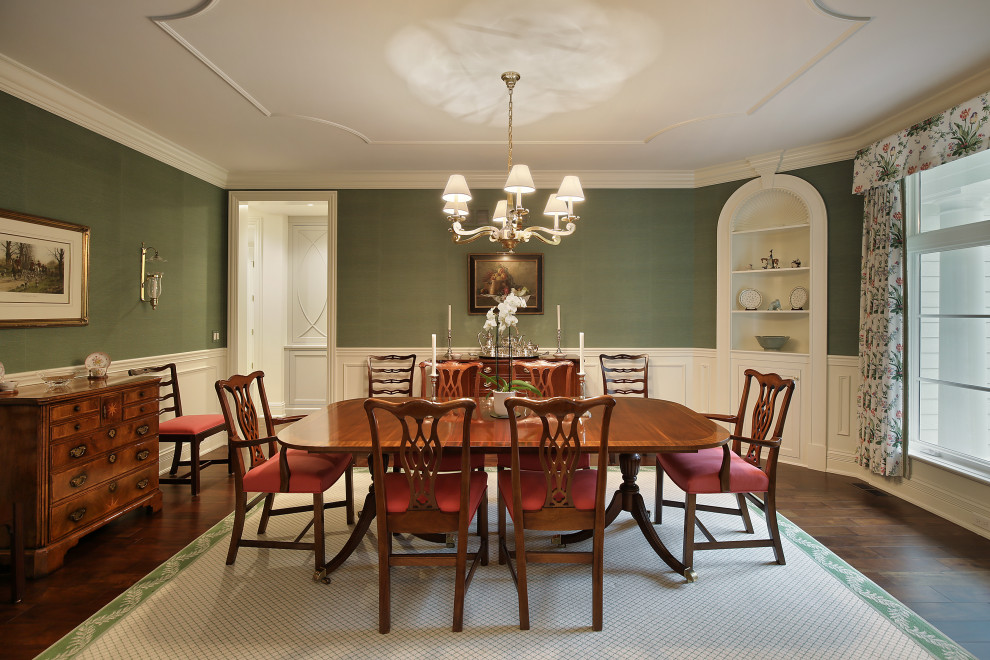 Photo of a traditional separate dining room in Chicago with green walls, dark hardwood floors, brown floor and decorative wall panelling.