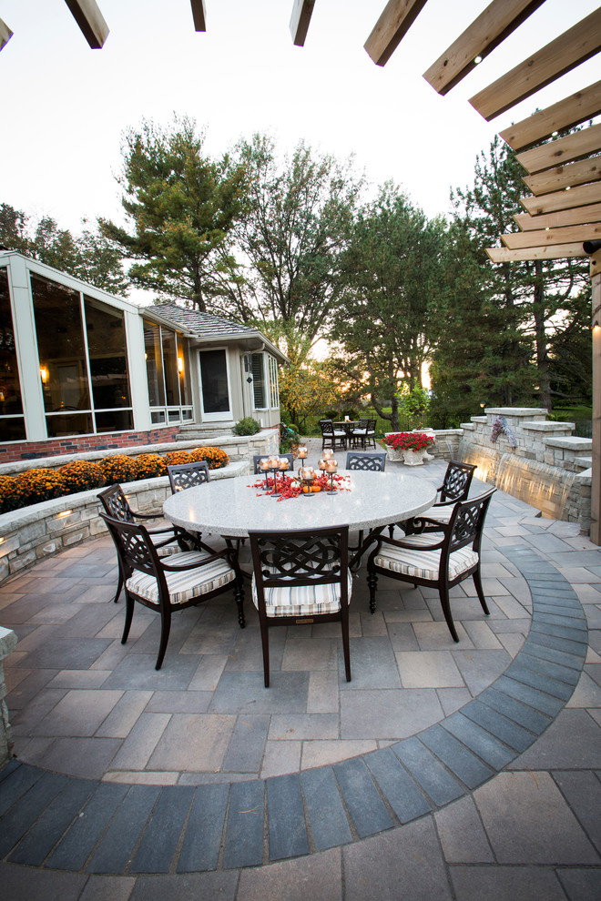 This is an example of a transitional backyard stone water fountain landscape in Omaha.