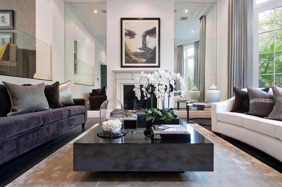 This is an example of a contemporary formal living room in Surrey with white walls, dark hardwood floors and a standard fireplace.