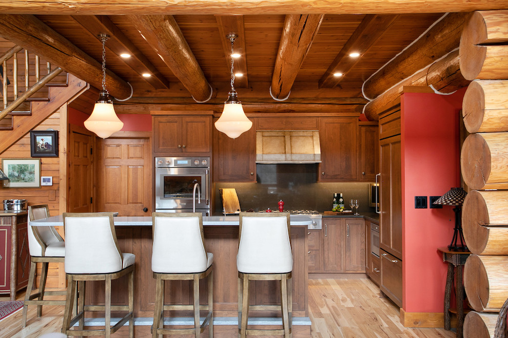 Kitchen - mid-sized rustic l-shaped light wood floor and beige floor kitchen idea in Milwaukee with medium tone wood cabinets, quartz countertops, gray backsplash, stone slab backsplash, gray countertops, shaker cabinets, paneled appliances and an island