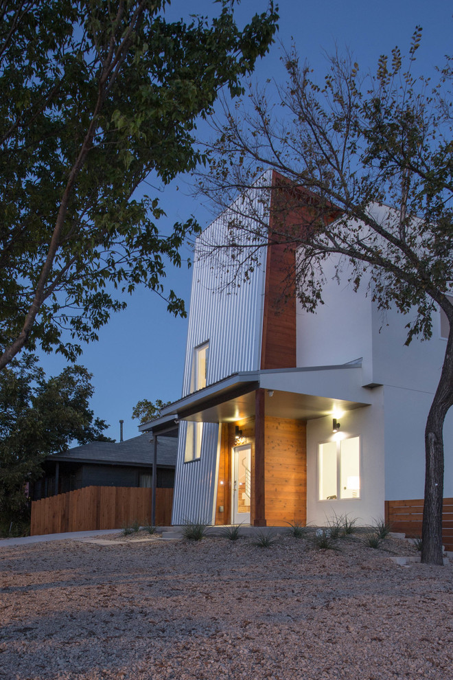 This is an example of a mid-sized modern two-storey stucco white exterior in Austin with a flat roof.
