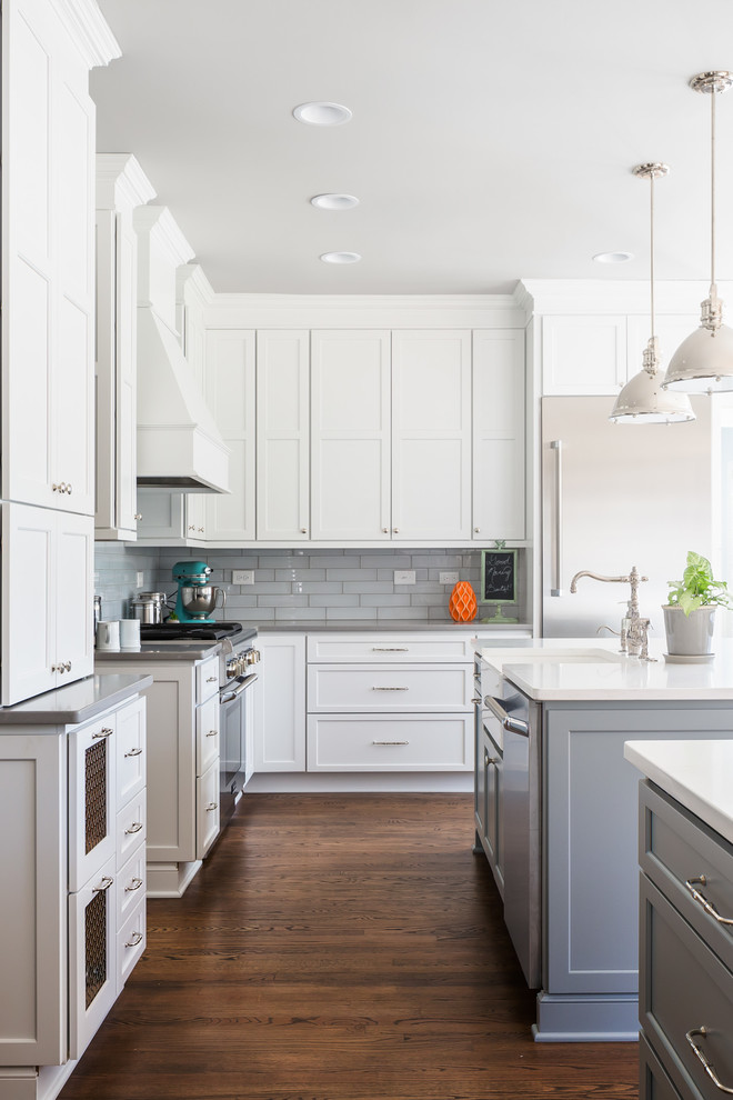 Example of a huge transitional galley medium tone wood floor open concept kitchen design in Raleigh with a farmhouse sink, flat-panel cabinets, white cabinets, quartz countertops, gray backsplash, ceramic backsplash, stainless steel appliances and two islands