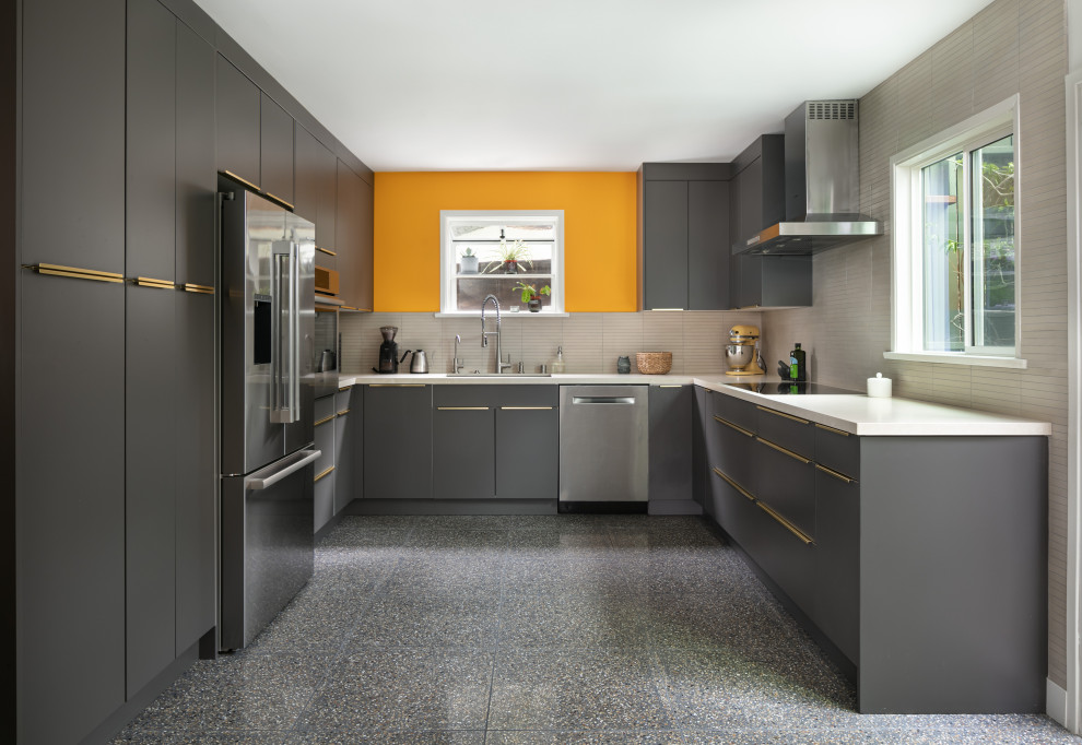 Inspiration for a mid-sized modern u-shaped separate kitchen in Los Angeles with an undermount sink, flat-panel cabinets, black cabinets, quartz benchtops, beige splashback, limestone splashback, stainless steel appliances, terrazzo floors, no island, black floor and beige benchtop.