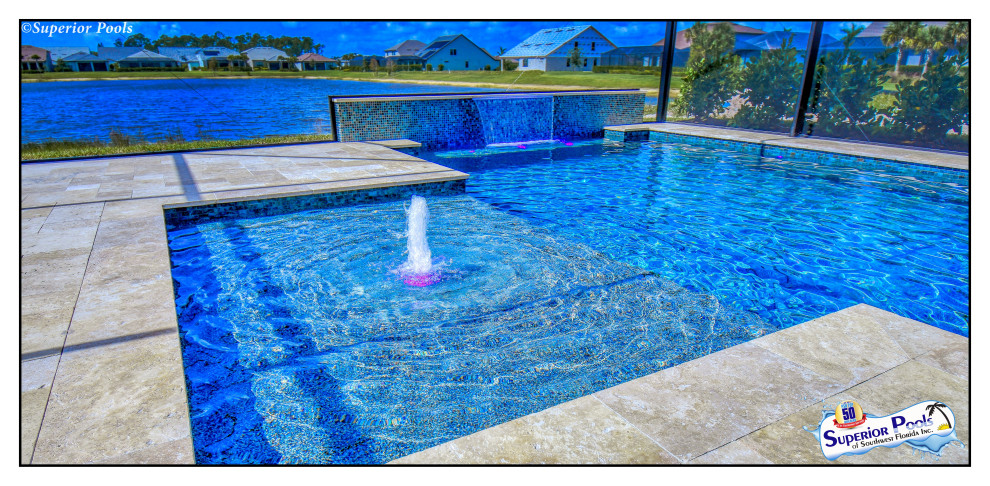 Photo of a mid-sized contemporary backyard rectangular pool in Tampa with natural stone pavers.