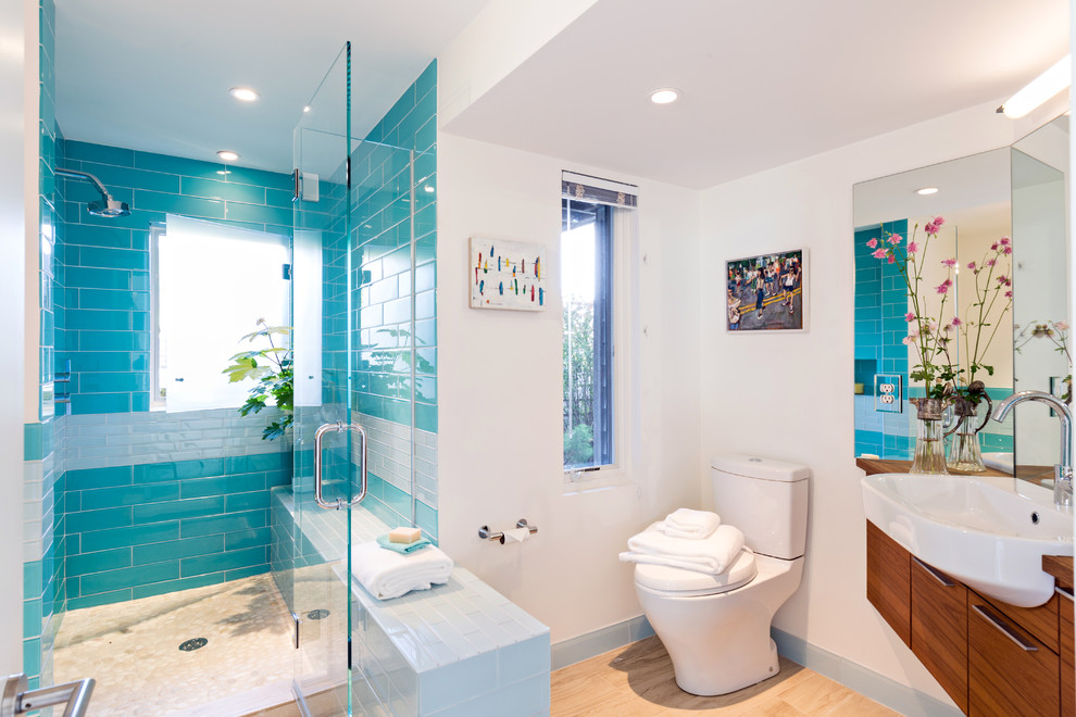 Design ideas for a beach style bathroom in Boston with flat-panel cabinets, dark wood cabinets, an alcove tub, glass tile, white walls, light hardwood floors, wood benchtops, blue tile and an alcove shower.