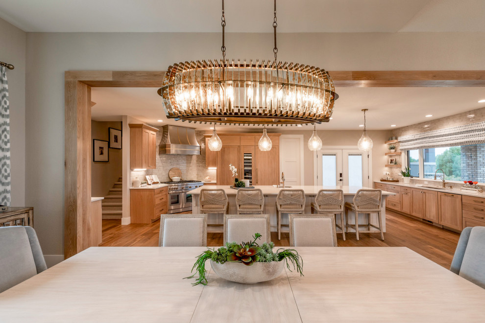 Large beach style u-shaped light wood floor eat-in kitchen photo in Denver with an undermount sink, shaker cabinets, light wood cabinets, quartz countertops, beige backsplash, ceramic backsplash, stainless steel appliances, an island and white countertops