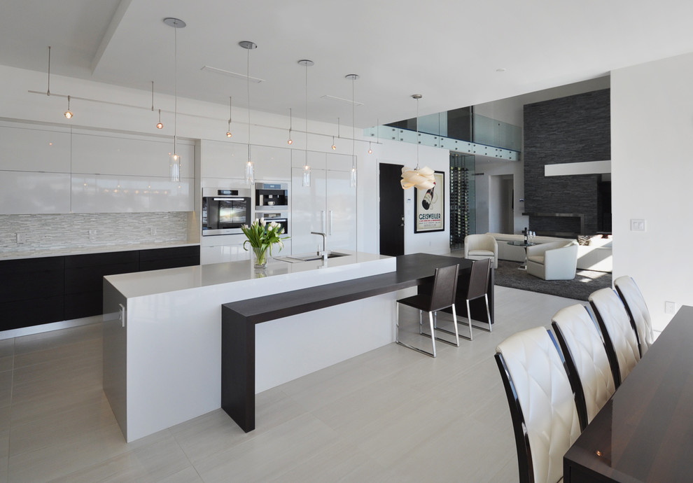Inspiration for a large modern u-shaped open plan kitchen in Albuquerque with an undermount sink, flat-panel cabinets, white cabinets, quartz benchtops, white splashback, matchstick tile splashback, stainless steel appliances, porcelain floors and with island.