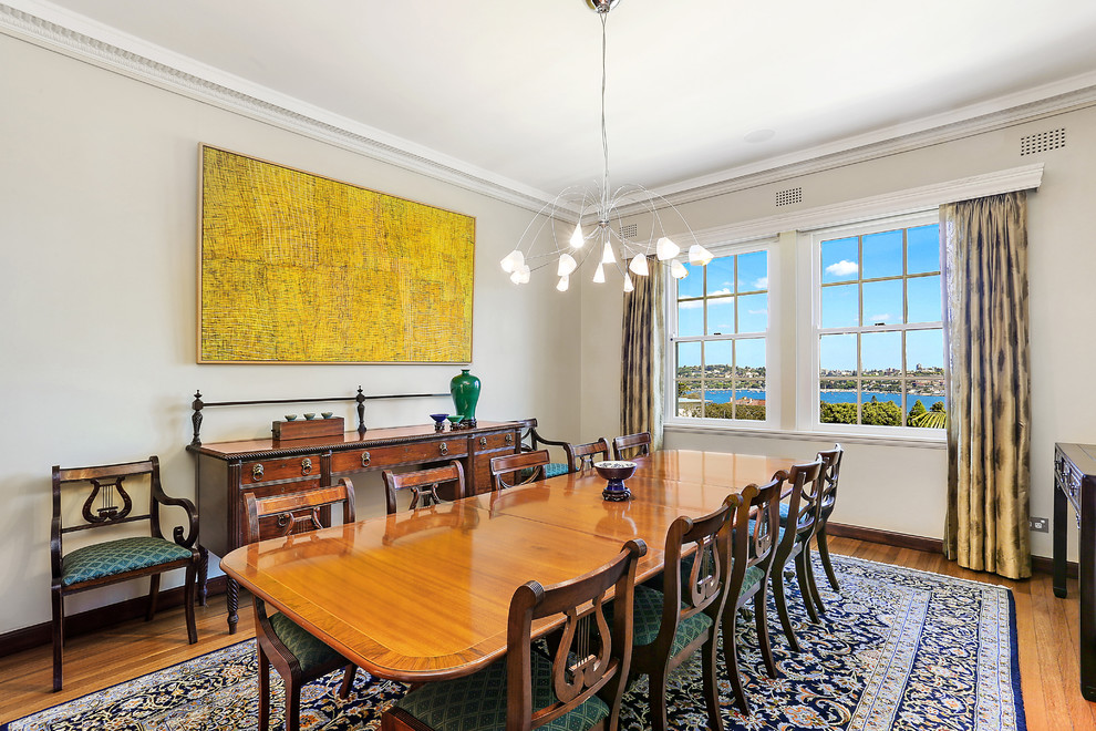 Photo of a mid-sized traditional separate dining room in Sydney with beige walls, medium hardwood floors and brown floor.