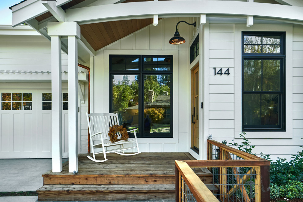 Foto på en mellanstor lantlig veranda framför huset, med trädäck och takförlängning