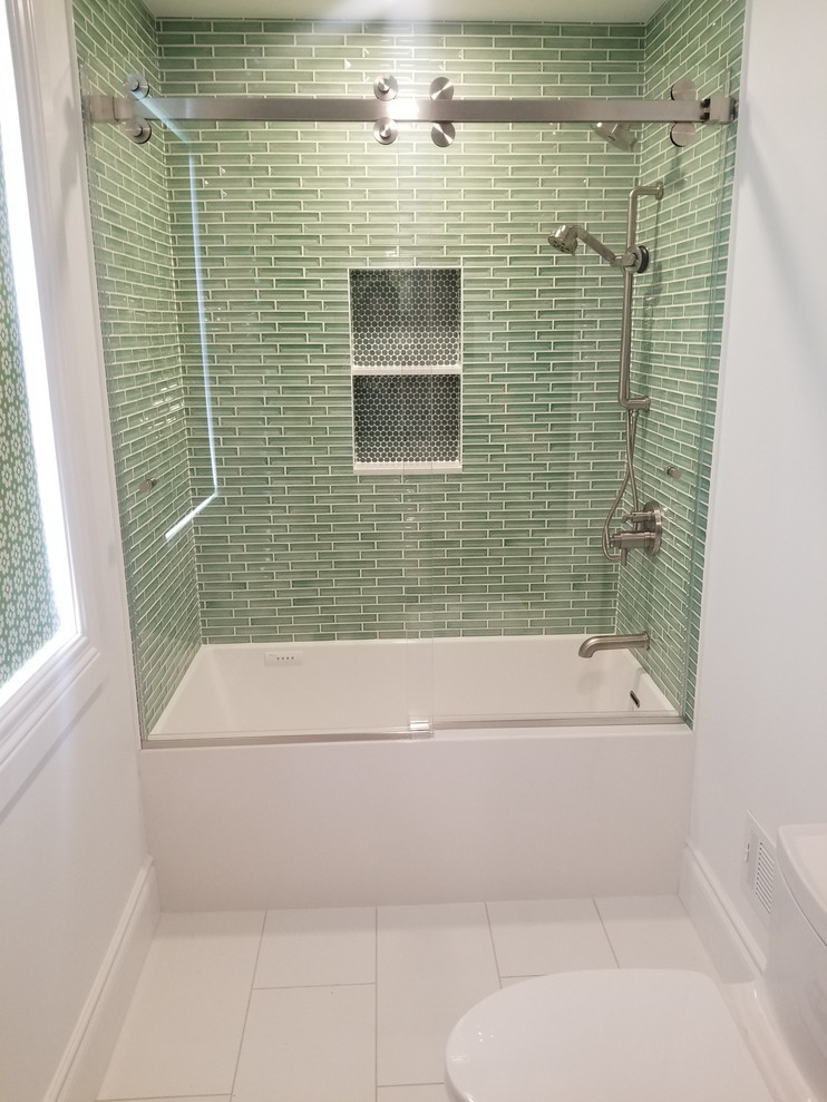 Inspiration for a midcentury bathroom in Detroit with an alcove tub, a one-piece toilet, green tile, white walls and porcelain floors.