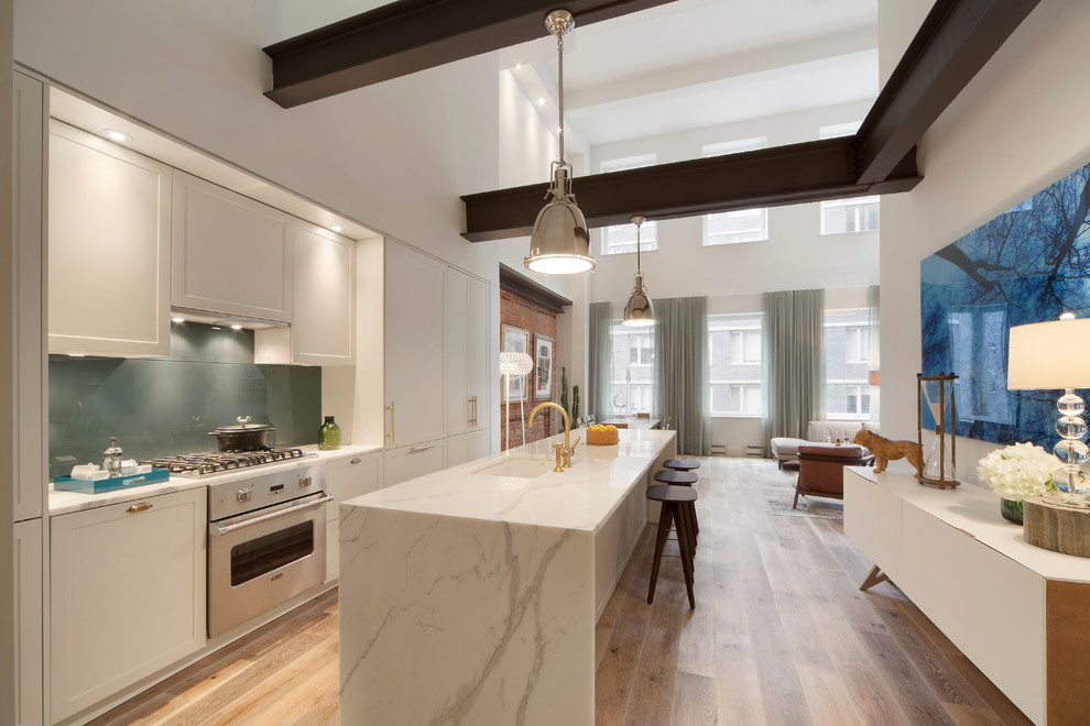 Inspiration for a mid-sized contemporary single-wall medium tone wood floor open concept kitchen remodel in New York with a single-bowl sink, shaker cabinets, white cabinets, marble countertops, gray backsplash, glass sheet backsplash, stainless steel appliances and an island