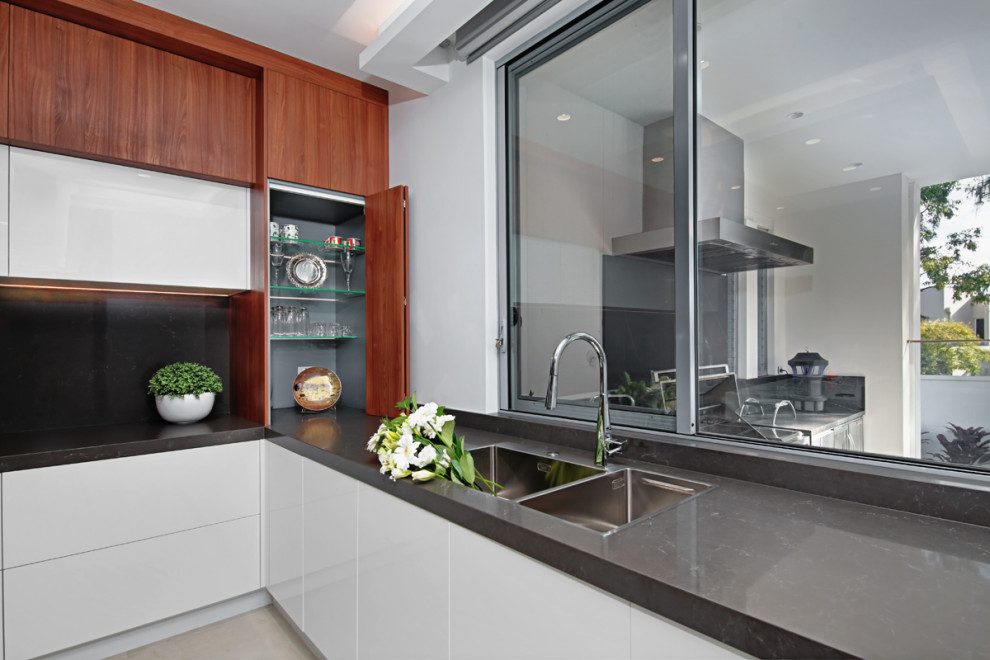 Inspiration for a mid-sized modern u-shaped open plan kitchen in Sydney with a double-bowl sink, recessed-panel cabinets, dark wood cabinets, marble benchtops, black splashback, marble splashback, black appliances, ceramic floors, with island, beige floor, black benchtop and coffered.