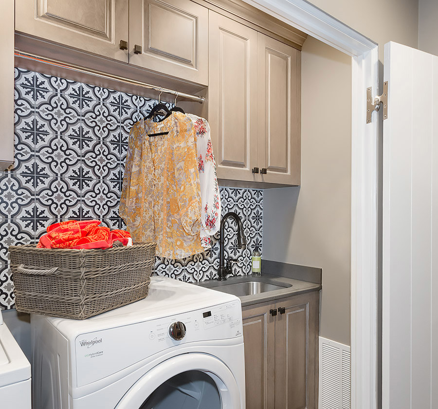Design ideas for a small traditional single-wall laundry cupboard in Chicago with an undermount sink, raised-panel cabinets, beige cabinets, granite benchtops, beige walls, medium hardwood floors, a side-by-side washer and dryer and brown floor.