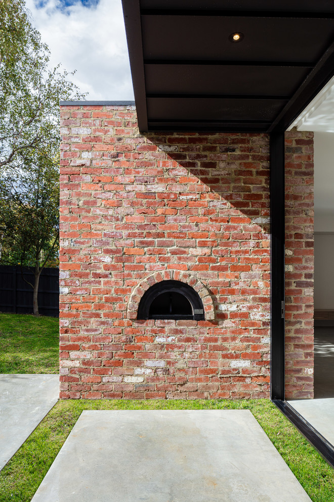 Inspiration for a large contemporary backyard patio in Melbourne with an outdoor kitchen, concrete slab and a roof extension.