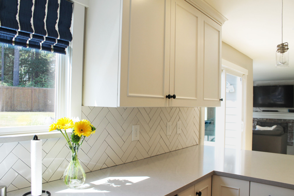 Eat-in kitchen - mid-sized transitional u-shaped medium tone wood floor eat-in kitchen idea in Seattle with an undermount sink, shaker cabinets, white cabinets, quartz countertops, white backsplash, ceramic backsplash, stainless steel appliances, a peninsula and gray countertops