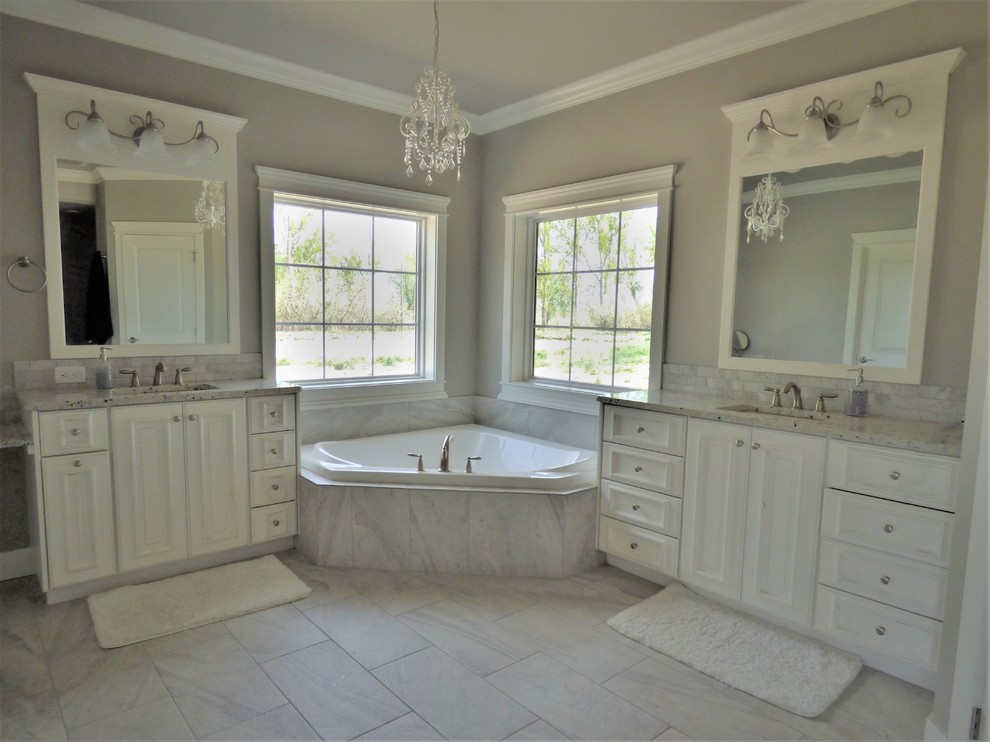 Mid-sized traditional master bathroom in Other with raised-panel cabinets, white cabinets, a corner tub, an open shower, a one-piece toilet, gray tile, white tile, marble, grey walls, ceramic floors, a drop-in sink, marble benchtops and an open shower.