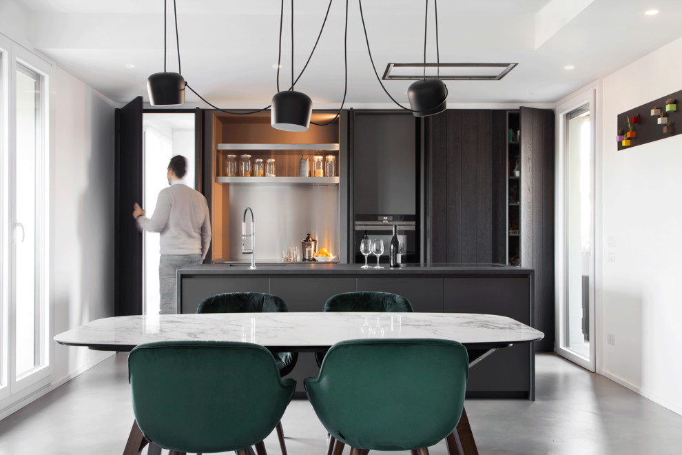 Inspiration for a mid-sized contemporary eat-in kitchen in Other with laminate benchtops, concrete floors, with island, grey floor, black benchtop, flat-panel cabinets, black cabinets and metallic splashback.