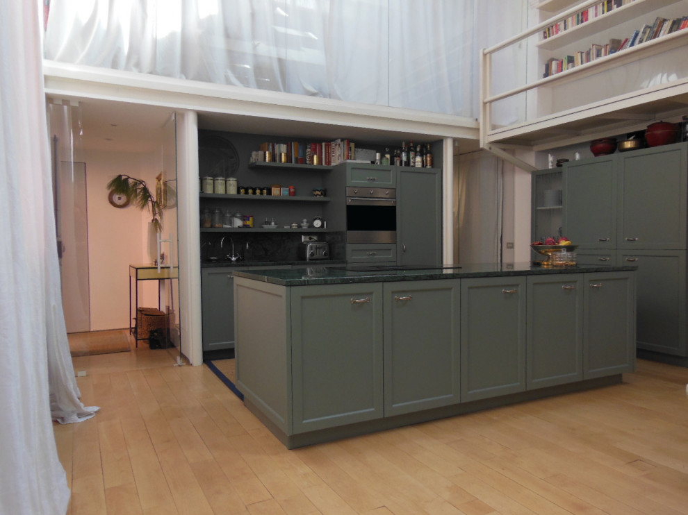 Design ideas for a large modern galley eat-in kitchen in Milan with an integrated sink, recessed-panel cabinets, green cabinets, marble benchtops, green splashback, marble splashback, stainless steel appliances, light hardwood floors, with island, green benchtop and exposed beam.