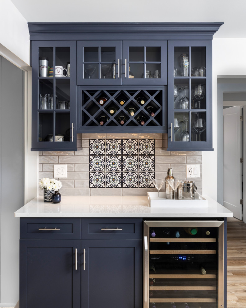 This is an example of a transitional galley home bar in Detroit with grey splashback, subway tile splashback and white benchtop.