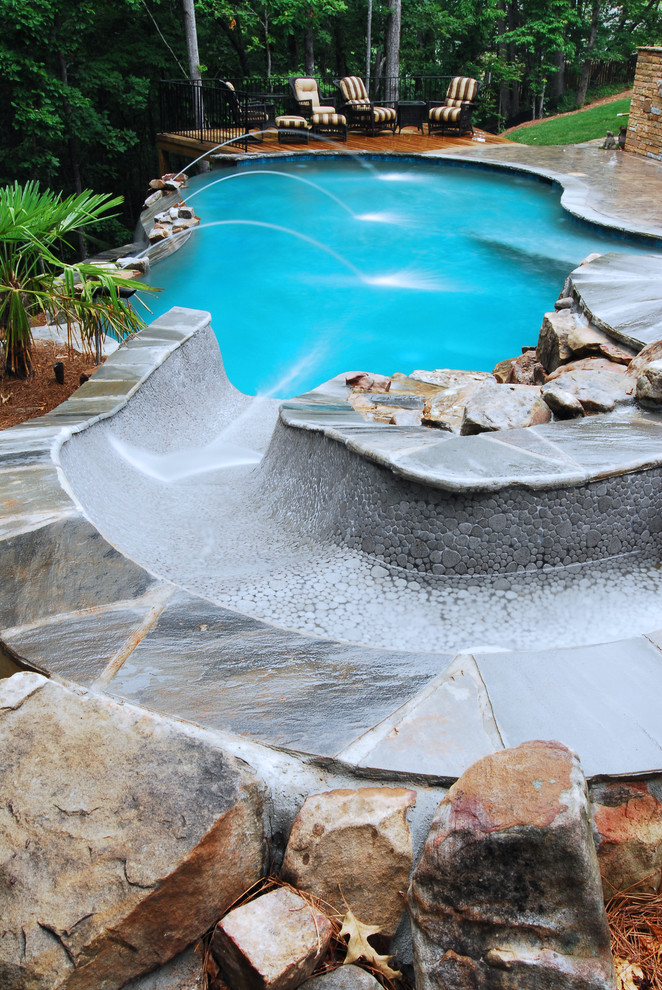 Water slide - large rustic backyard kidney-shaped infinity water slide idea in Atlanta