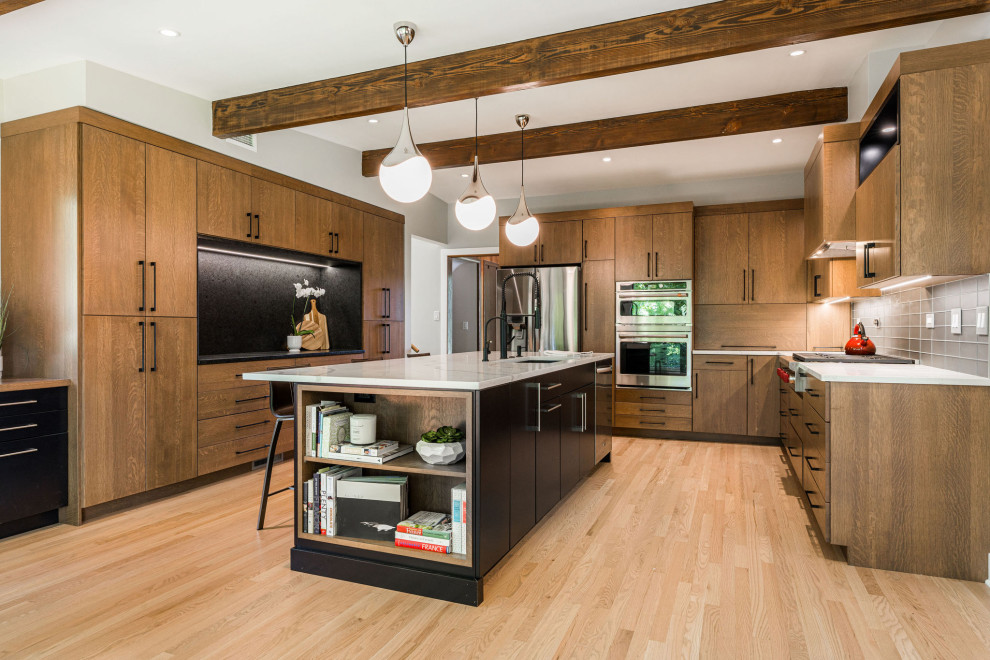 Inspiration for a large midcentury eat-in kitchen in Chicago with medium wood cabinets, quartzite benchtops, metallic splashback, light hardwood floors, with island and white benchtop.