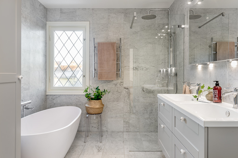 Inspiration for a transitional wet room bathroom in Stockholm with shaker cabinets, grey cabinets, a freestanding tub, gray tile, an integrated sink, grey floor, an open shower and white benchtops.