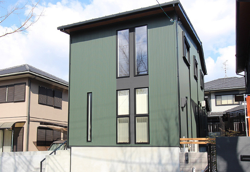 Inspiration for a scandinavian two-storey green house exterior in Osaka with a black roof.
