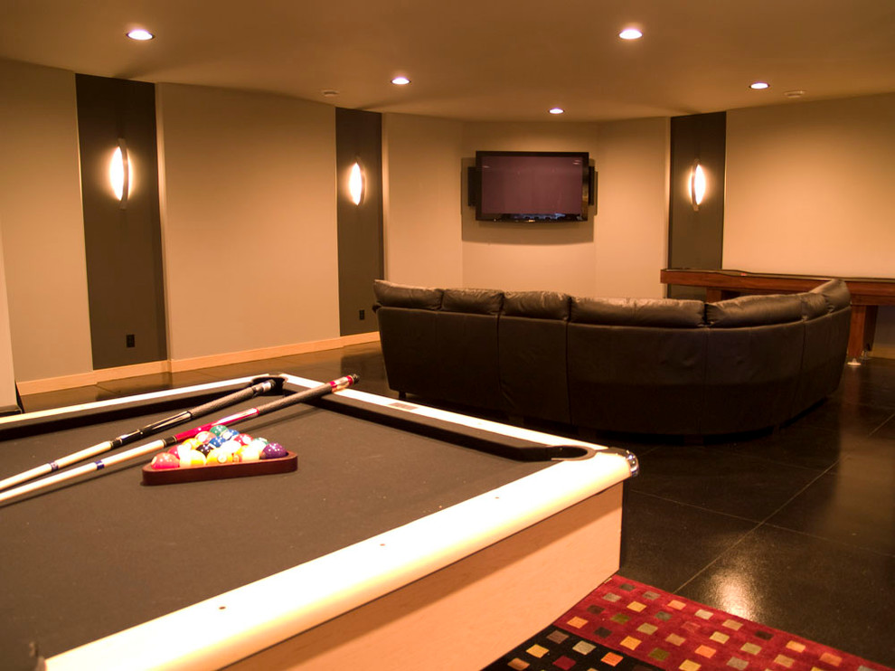 Mid-sized contemporary enclosed home theatre in Other with beige walls, concrete floors and a wall-mounted tv.