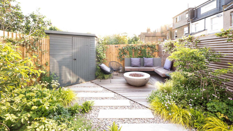 Photo of a small contemporary backyard deck in London with a fire feature.