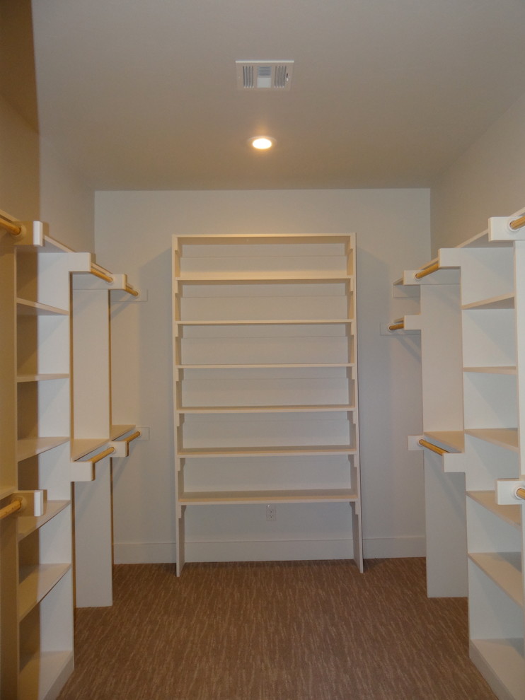 Inspiration for a large mediterranean walk-in wardrobe in Austin with open cabinets, white cabinets and carpet.